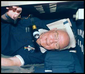 Flashlight floating in front of John Glenn