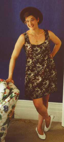 [Karin in a short brown floral dress in the Blue 
Parlor of Glen Park Residence Hall]