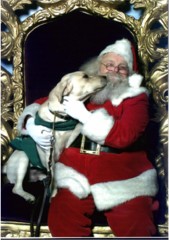 Pele sitting next to the mall Santa. Pele leaning over and kissing Santa