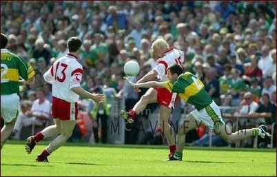 Eoin Mulligan gets his kick away despite Michael McCarthy's attempt to block at the Bank of Ireland Football Semi-Final between Tyrone & Kerry in Croke.