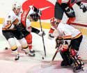 Lumme checking Lindros, McLean guarding net
