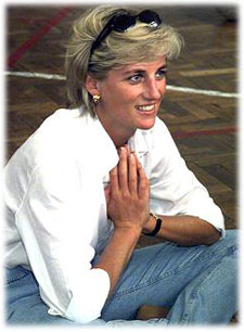 Diana squatting, wearing blue jeans, a white shirt, and sunglasses