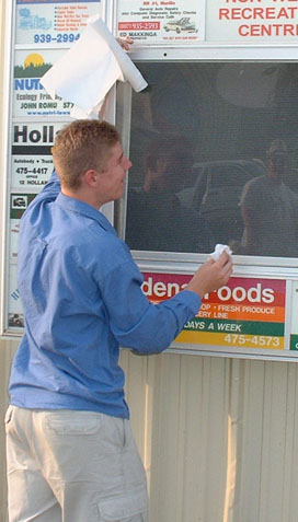 To break the long drive, Ryan cleans a Brooklin Sign at Kakebeka Falls - Norwest Rec Ctr