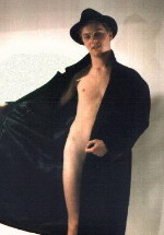 Young boy in just a black coat, half open.