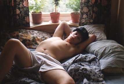 Relaxed on bed, just boxer shorts.