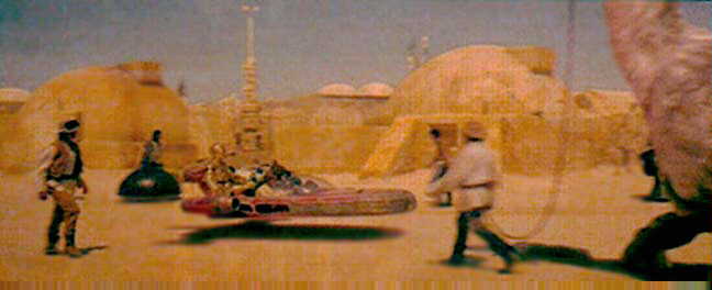 Land Speeder entering Mos Eisley.  What the heck is that guy walking!?!