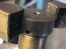Friction surfaces on this very old shock were renewed with brass, probably (from the drips on the edges) put down by brazing.  Whoever did it was an artist.
