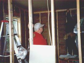 Vicky putting sheetrock up on ceiling