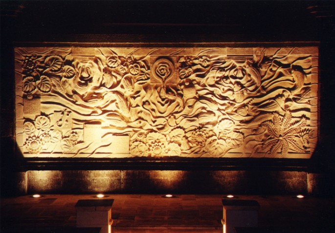 Night view of stone wall carving at Pool Grill of Le Meridien Hotel, Bali