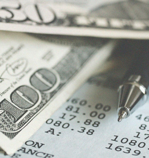 Photo of a pen, money and calculated sheet