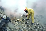 Scientist collecting gas sample from a fumarole on Mageik volcano Alaska