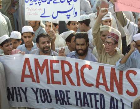 Tens of thousands in Pakistan have protested because their government opened their airspace to U.S. warplanes; their sign reads, 'Americans, think! Why are you hated all over the world?'