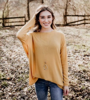 A gold colored, textured, light weight, long sleeved sweater.