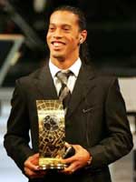Ronaldinho smiles as he hold the tropy
