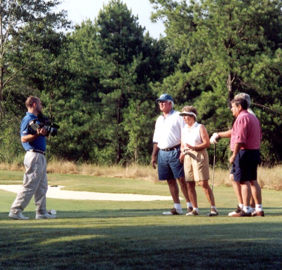 Video camera man giving direction to foursome