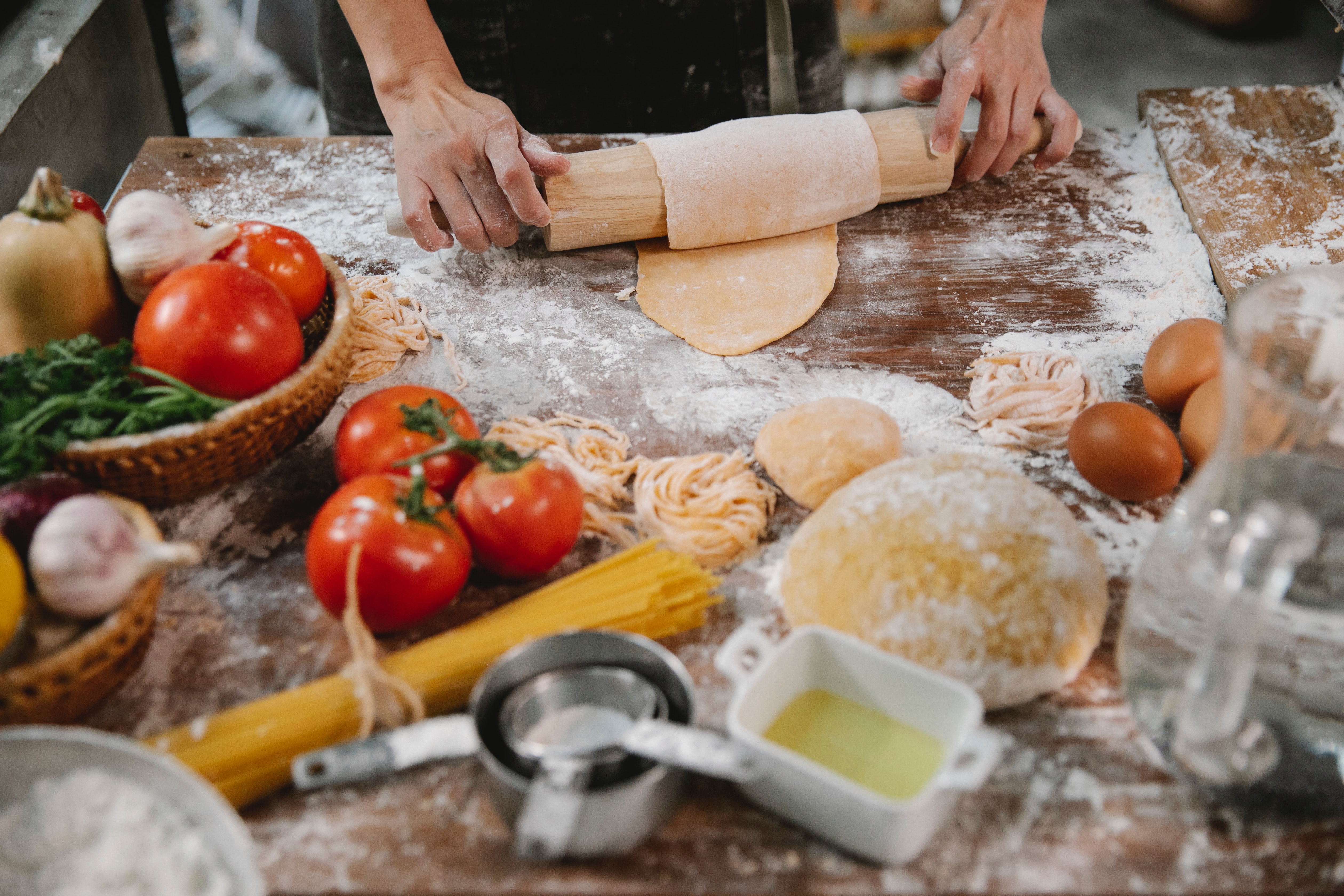 pasta dish with tomatos basil and wooden spoon image