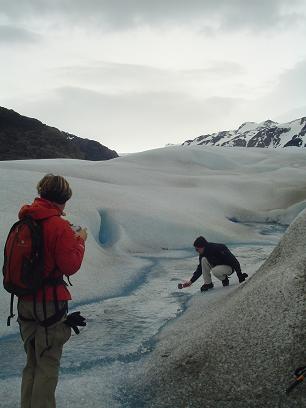 Dos de nuestros pasajeros tomando agua de deshielo durante una pausa en la caminata