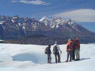 David conversando con algunos pasajeros. al fondo se ve, a la derecha, las cumbres nevadas del Paine Grande y a la izquierda el cord�n Olgu�n