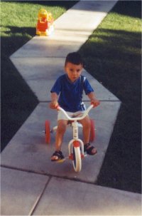 Louis is riding his tricycle