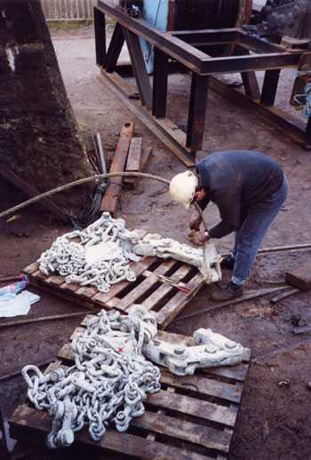 Checking the new chains before fitting them to the cage and rope