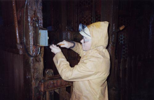 Photo of an electrician testing the electric signals on Robinson shaft cage at South Crofty.
