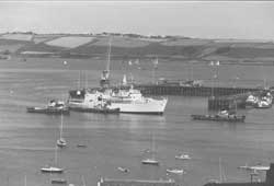 H.M.S. Hecate (Survey vessel) being towed by local tugs. Circa 1980's.