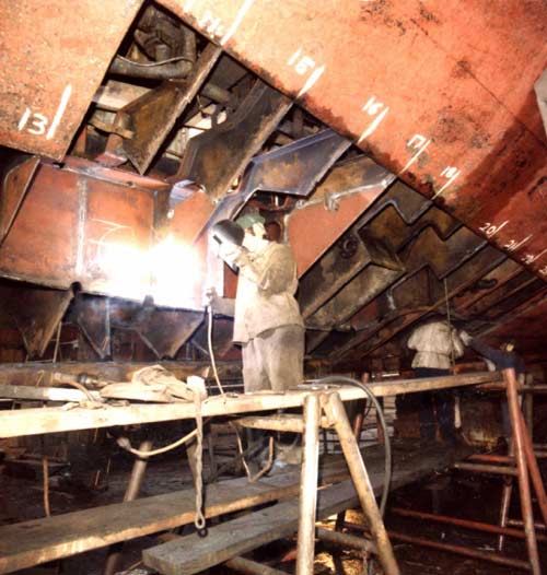 Welder working on the hull of ship. Circa 1980's.