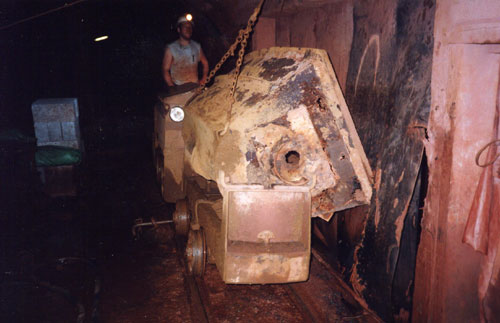 Photo of tin miner and wagon unloading ore at 310 level at South Crofty.