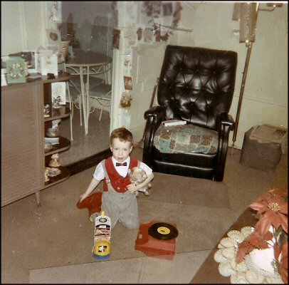 Jan. 1967. Looking very fey in my bowtie and showing off my Christmas presents: stuffed That Darn Cat, Fisher Price Old Lady in the Shoe, and Close n Play phonograph.