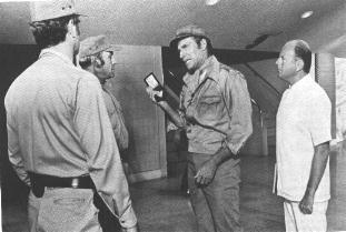 CHUCK SHOWING HIS BADGE