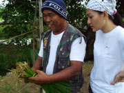A local demonstrating how to tie rice seedlings in a bundle.