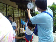 A student weighing a child in the community.