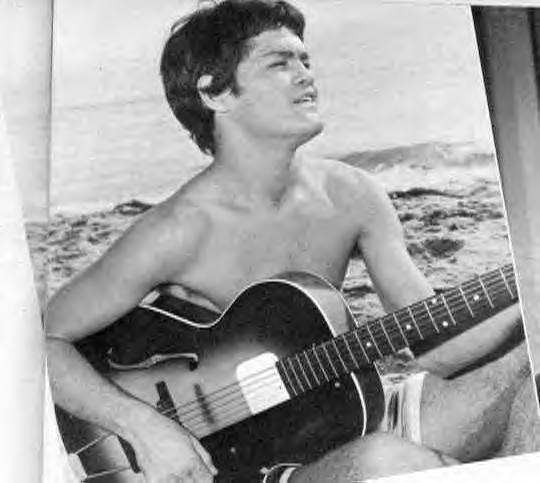 Micky playing guitar on the beach