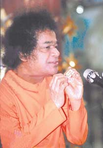 Sai Baba with materialised Bible, Christmas Day, 1996