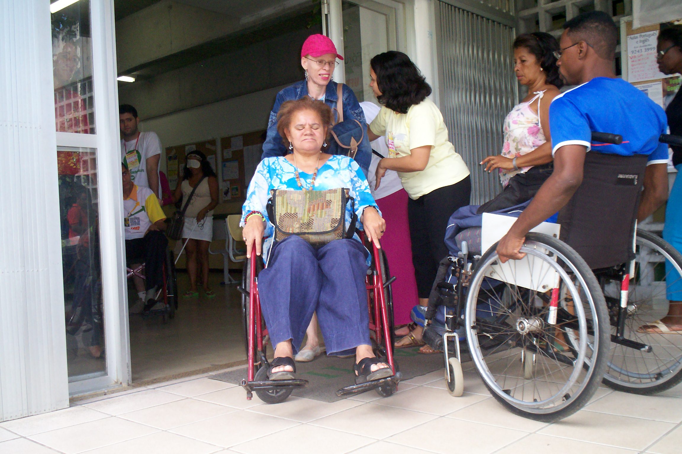 Na oficina da Cocas, uma participante � conduzida em uma cadeira de rodas pelo pessoal da Cocas.