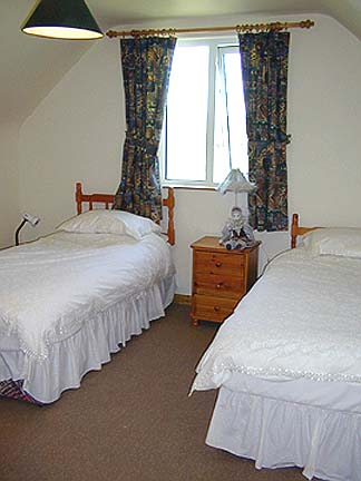 The room contains twin beds and a footon for a third person
