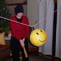 mom is first at bat at he traditional christmas smiling piniata....