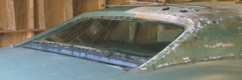 Rear window vent panel removed.  How am I ever going to get the embossed Cayman Grain pattern out?