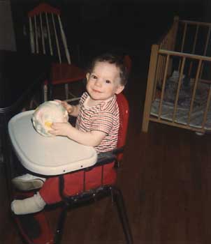 Infant Craig in high chair with ball