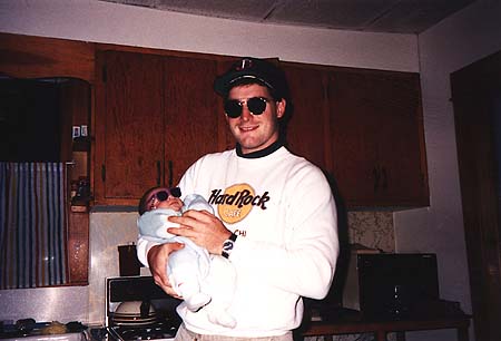 1990 - Craig and newborn Maxwell in kitchen, both wearing sun glasses