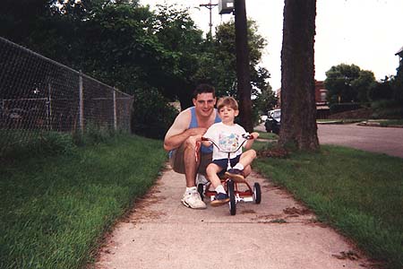 Craig teaching Maxwell to ride a tricycle
