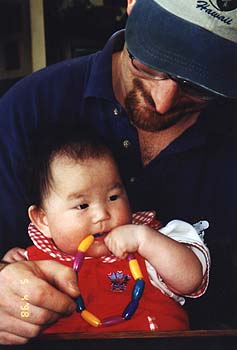 May 1998 - Craig and Zoey, Zoey's chewing on a ring of plastic beads
