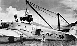 1933 photograph of Dr Ian Dickson�s baby Austin being unloaded at Wau from Guinea Airways Junkers G31 (VH-UOW) with chief pilot Bob Gurney standing on the fuselage. The hatch in the roof was made to carry large cargo.