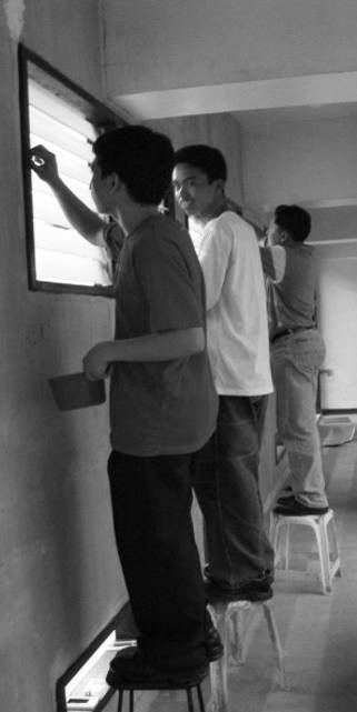 Some youth volunteers from a young men�s group happily extend their hands in cleaning the windows and walls.