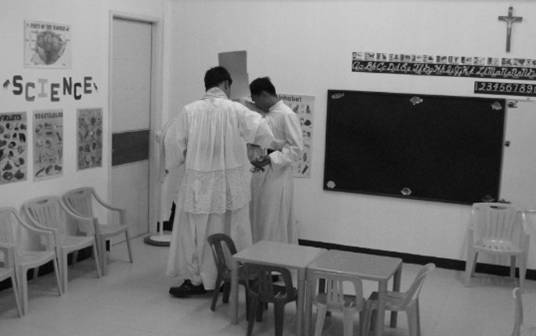 Fr. Soliman, assisted by Bro. Hyacinth, blesses the classrooms. 