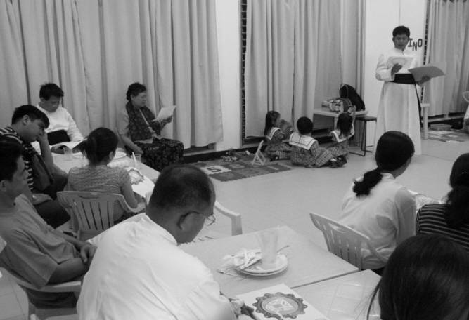 Fr. Soliman explains to the parents and visitors the meaning of the symbols in the coat of arms of the school.