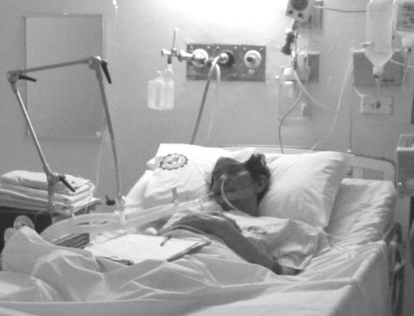 Fr. Santiago Hughes in bed with the various hospital apparatuses of St. Luke�s Medical Center, a hospital near the church.