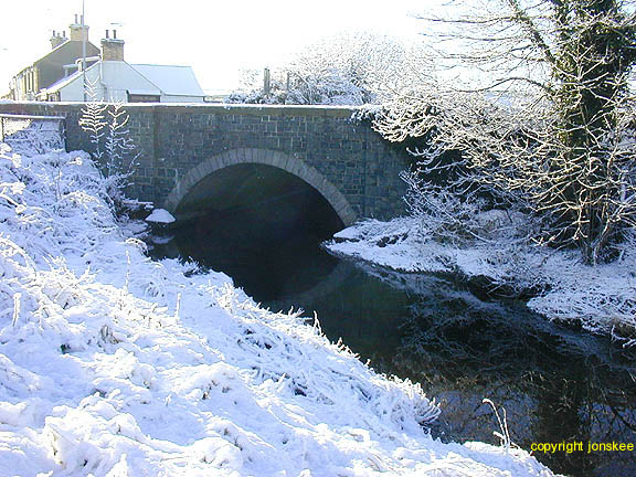 The river provides a sharp contrast to the whiteness of the snow.