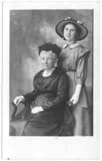 
(same photo shoot) Emma seated and Milly standing behind her
