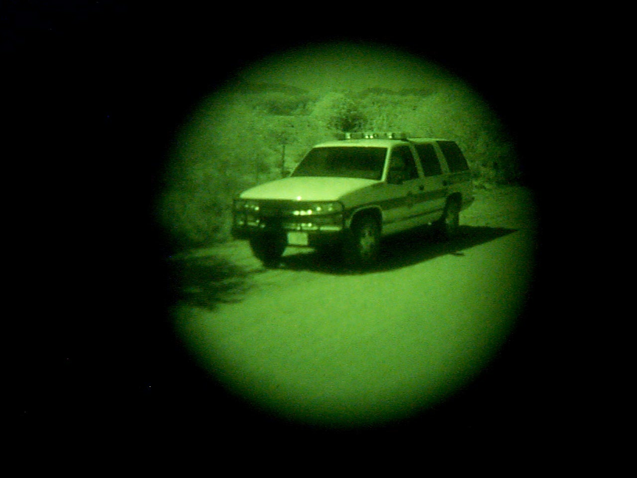 A Border Patrol vehicle as seen through a night vision scope